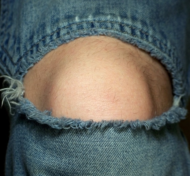 Ripped jeans tipe lubang di lutut, memberikan kesan urakan ala 90-an